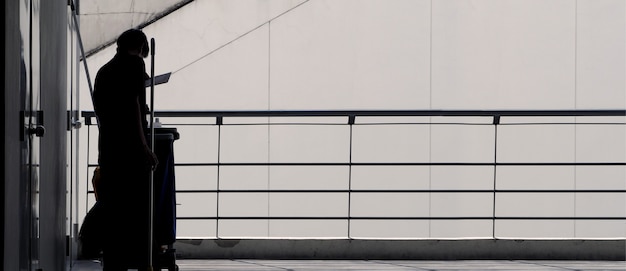 Silhoutte-Bilder von Reinigungsdienstmitarbeitern, die rund um die Terrasse im Gebäude für hygienische Arbeiten arbeiten