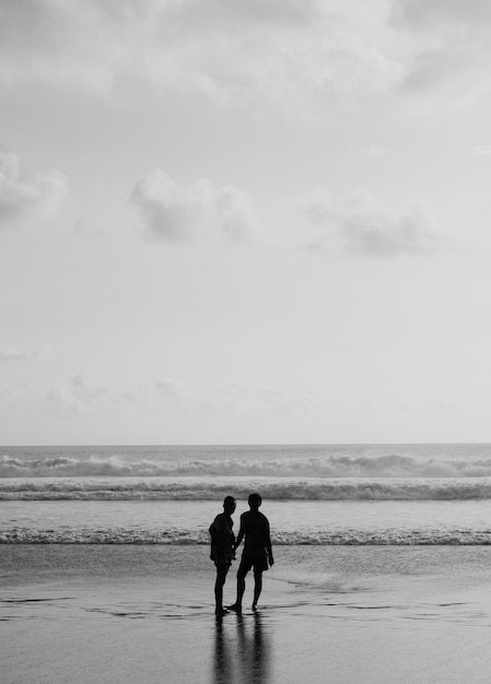 Silhoutte de dois amigos na praia