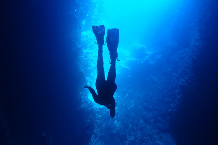 Foto silhueta de buceo en cueva de toda la longitud en las aguas azules del mar de vavau tonga