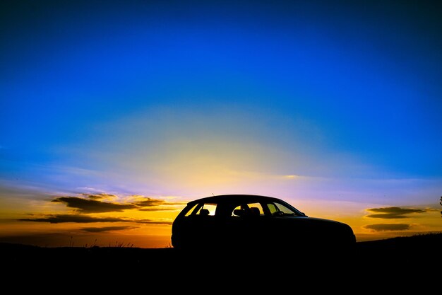 Foto silhueta de coche en el paisaje contra el cielo al atardecer