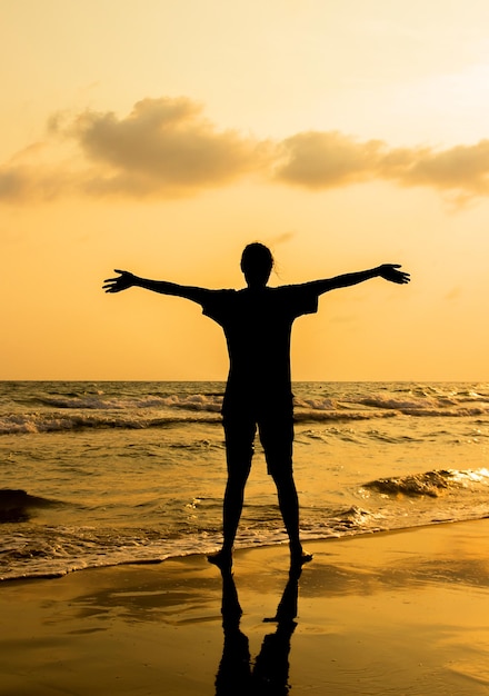 Foto silhueta com pessoas fica na praia com fundo por do sol