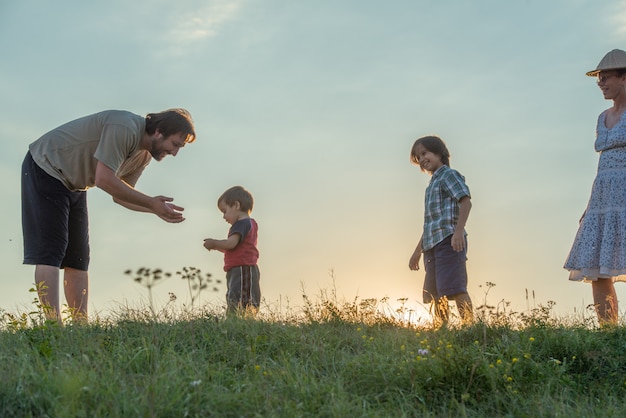 silhueta da família feliz se divertindo no penhasco