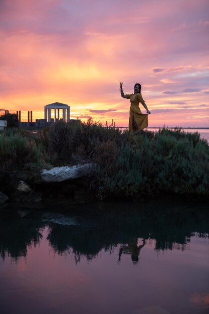 Silhueta da mulher no pôr do sol na praia do mar