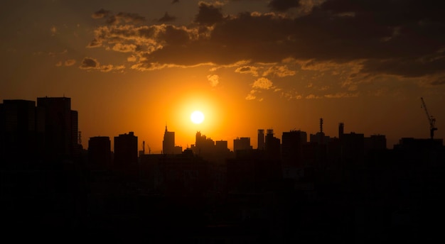 Silhueta da paisagem urbana contra o céu durante o pôr do sol