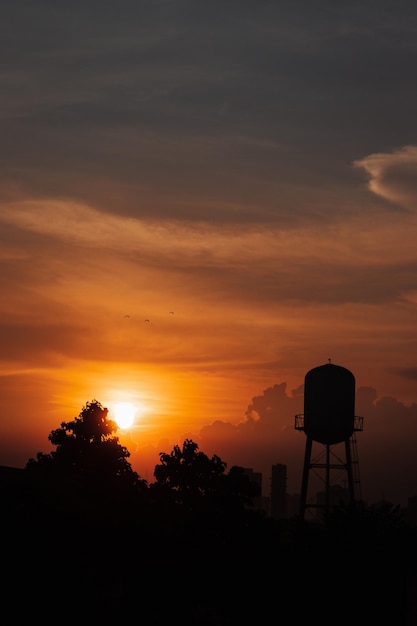 Foto silhueta da torre de água contra o céu durante o pôr do sol