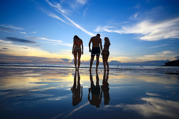 silhueta de amigos pôr do sol mar verão / grupo de jovens amigos homens e mulheres no verão descansar e se divertir no mar, feliz pôr do sol do mar