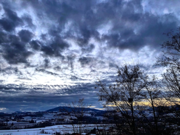 Foto silhueta de árvores nuas em uma paisagem coberta de neve contra o céu