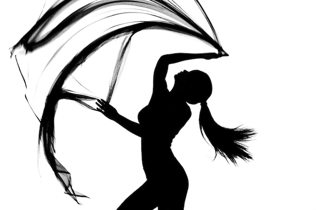 Silhueta de body feminino com meio corpo dançando com tecido transparente em preto e branco, jogando pano se movendo no ar e desfocando o movimento para mostrar corpo magro sexy em estúdio, fundo branco isolado