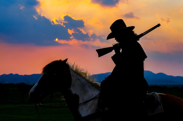 Silhueta de caubói em um cavalo durante o belo pôr do sol