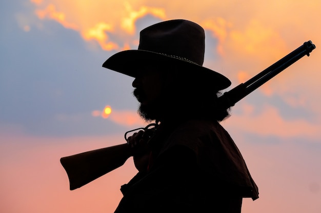 Silhueta de caubói em um cavalo durante o belo pôr do sol