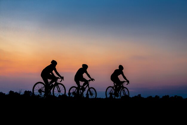 Foto silhueta de ciclista em movimento no fundo do belo pôr do sol