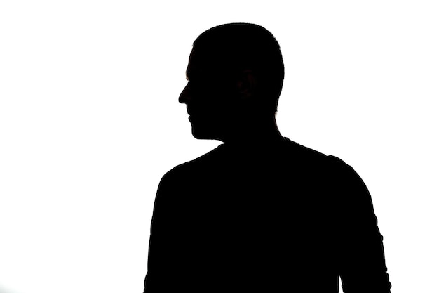 Foto silhueta de costas adultas do homem olhando para longe no estúdio em fundo branco