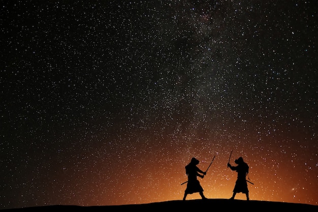 Silhueta de dois samurais contra o céu estrelado. Guerreiros mortais com espadas