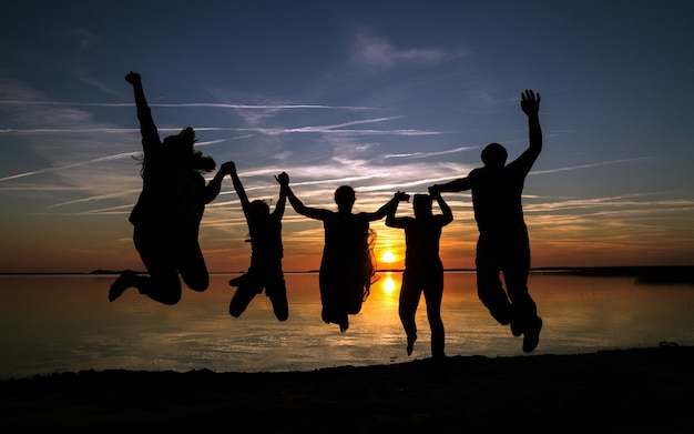 Silhueta de família feliz na praia