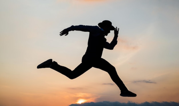 Silhueta de homem correndo no sentido de liberdade na resistência do céu ao nascer do sol