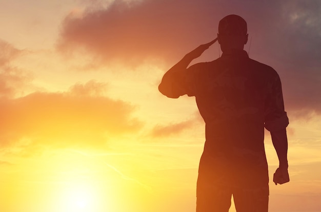 Silhueta de homem jovem soldado militar no fundo do pôr do sol