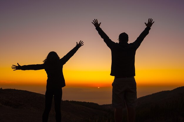 Silhueta de jovens ao pôr do sol no topo do Monte Teide, na Ilha de Tenerife