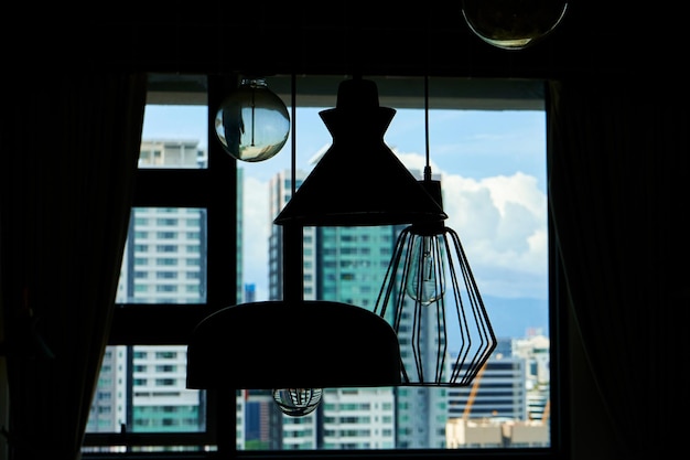 Silhueta de lâmpadas modernas de loft contra a janela panorâmica