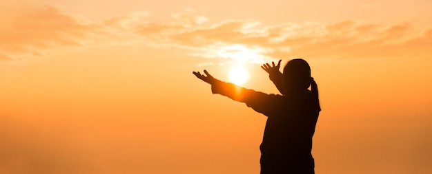 Foto silhueta de mão de mulher rezando espiritualidade e religião adoração feminina a deus banner com espaço de cópia pessoas religiosas são humildes a deus os cristãos têm esperança fé e fé em deus