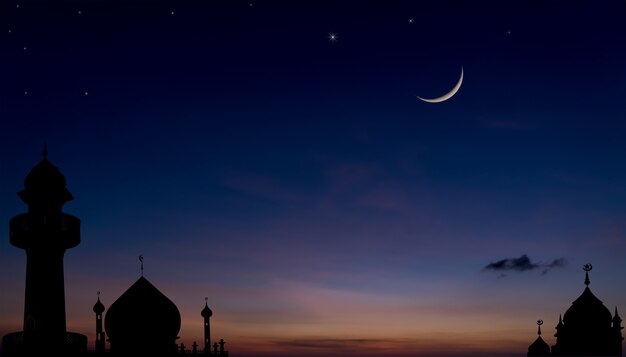 Foto silhueta de mesquitas no crepúsculo do crepúsculo após o pôr do sol com a religião muçulmana da lua crescente