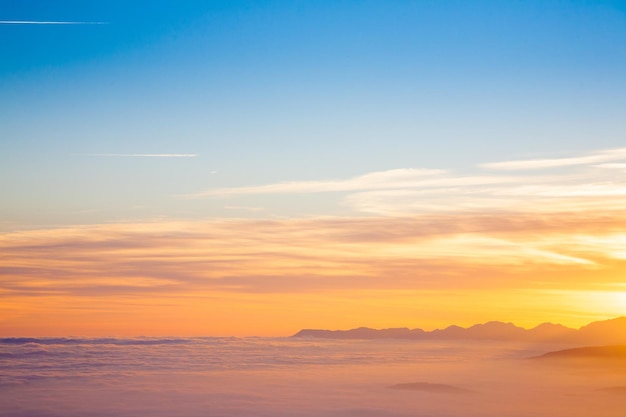 Silhueta de montanha ao pôr do sol do fundo das nuvens dos alpes italianos