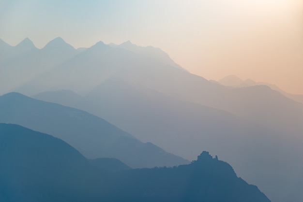 Silhueta de montanha tonificada azul e perfil de abadia ao pôr do sol