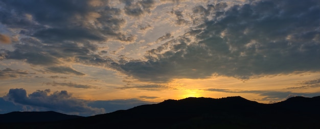 Silhueta de montanhas com lindo pôr do sol com o sol poente