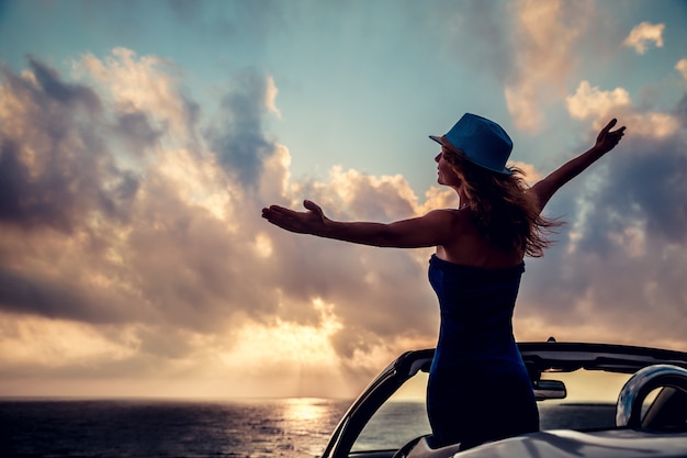 Foto silhueta de mulher bonita relaxando na praia pessoa se divertindo no cabriolet contra o céu azul férias de verão e conceito de viagens