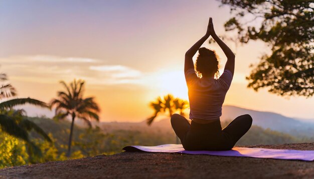 Silhueta de mulher em postura de ioga contra o pôr-do-sol representando tranquilidade e atenção na natureza