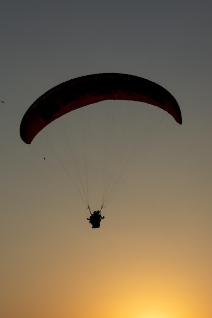 Silhueta de parapente ao pôr do sol em Oludeniz