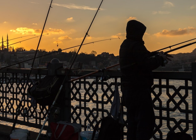 Foto silhueta de pescador durante a imagem de luz reversa senset