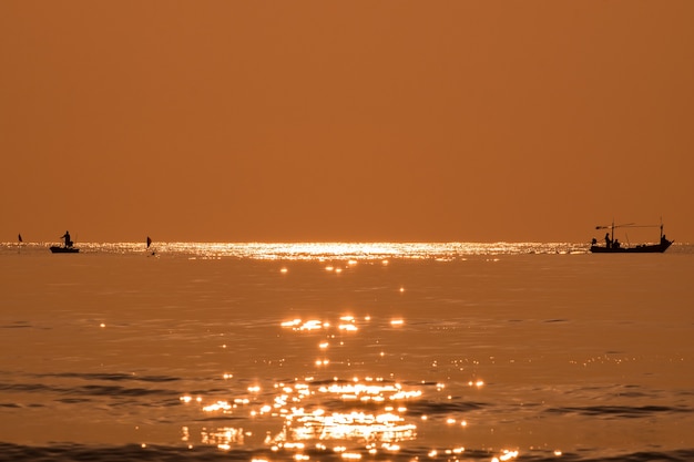 Silhueta de pescador pescando mar dourado lindo brilho natural de manhã