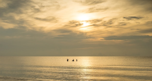 silhueta de pescadores com o nascer do sol no fundo
