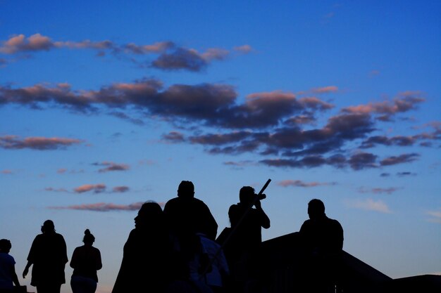 Foto silhueta de pessoas contra o céu durante o pôr-do-sol