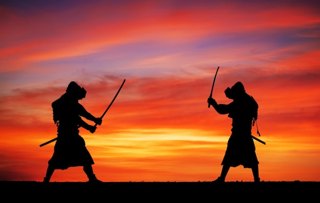 Silhueta de samurais em duelo. Foto com dois samurais e o céu do pôr do sol