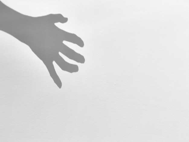 Foto silhueta de sombra de mão assustadora no ruído de espaço de cópia de parede cinza