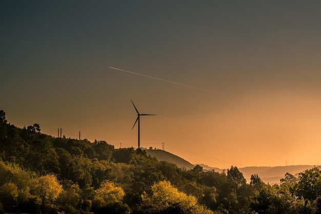 Silhueta de turbinas eólicas na paisagem contra o céu durante o pôr do sol