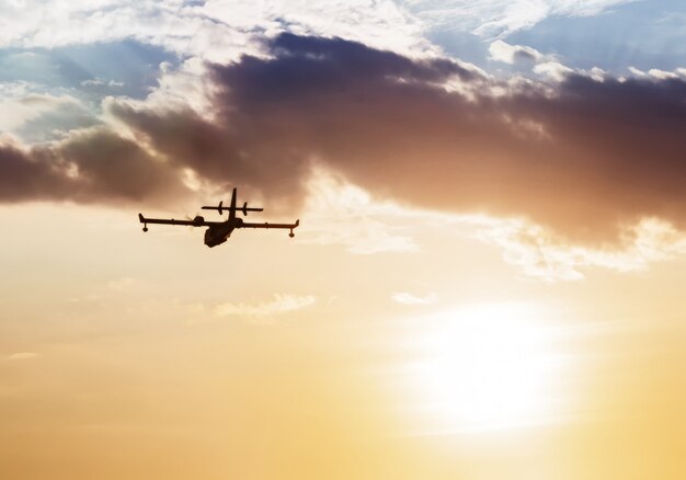 Silhueta de um avião ao pôr do sol.