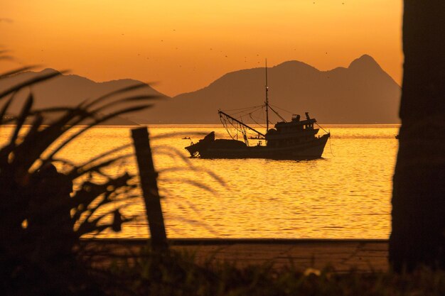 Silhueta de um barco de pesca na praia vermelha da Urca no Rio de Janeiro Brasil