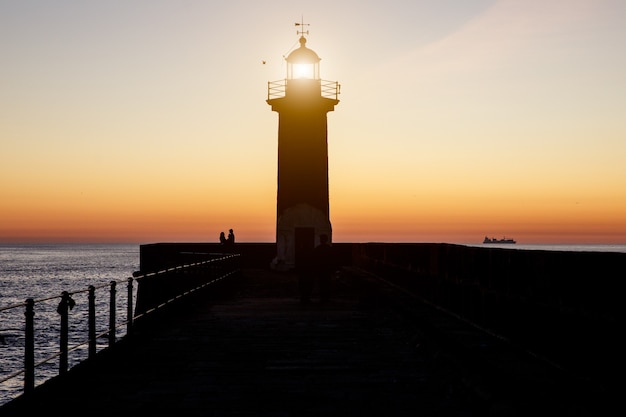 Silhueta de um farol ao pôr do sol