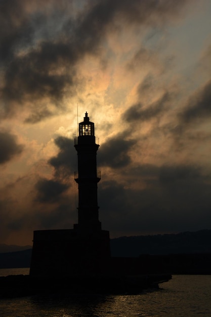 Silhueta de um farol contra um céu nublado