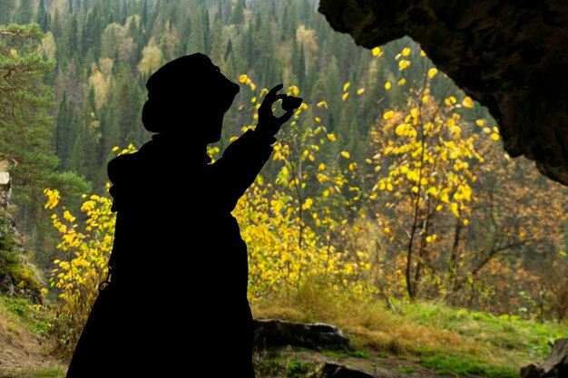 Silhueta de um geólogo examinando uma amostra mineral encontrada em uma caverna