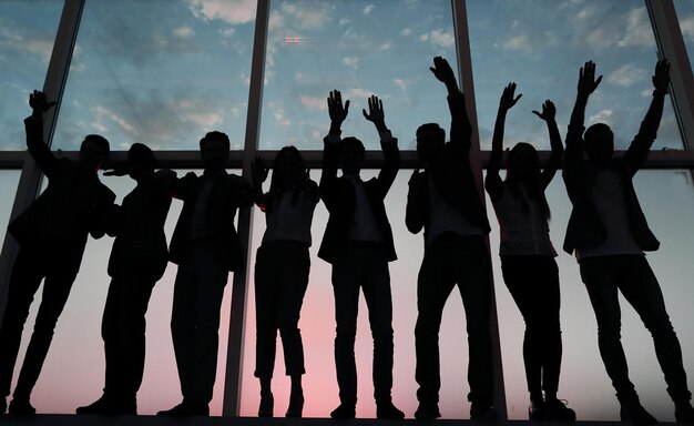 Foto silhueta de um grupo de empresários levantando a mão