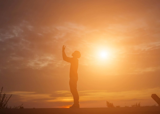 Foto silhueta de um homem de pé contra o céu durante o pôr do sol