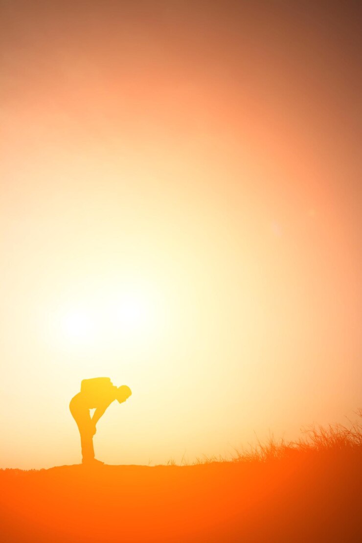 Foto silhueta de um homem de pé contra o céu no campo durante o pôr do sol