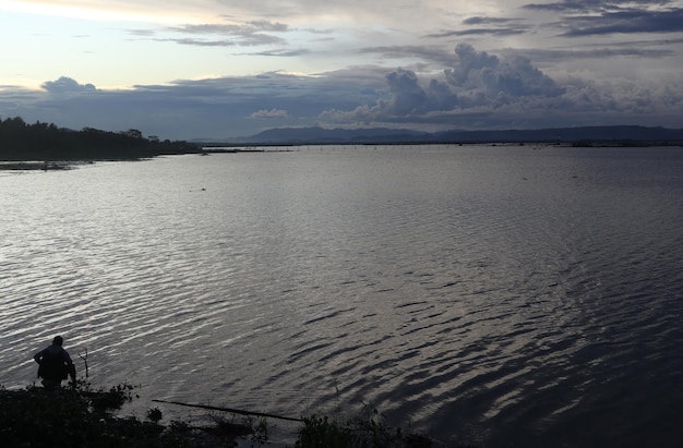 Silhueta de um homem pescando à tarde