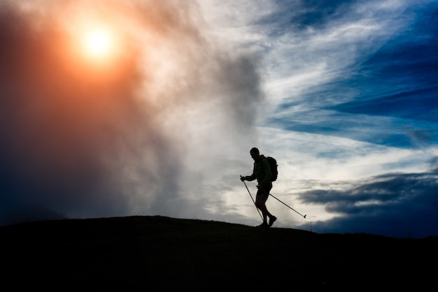 Silhueta de um homem trekking em uma montanha