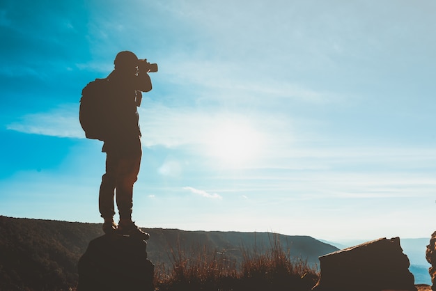 Silhueta de um jovem fotógrafo de viagens com uma mochila