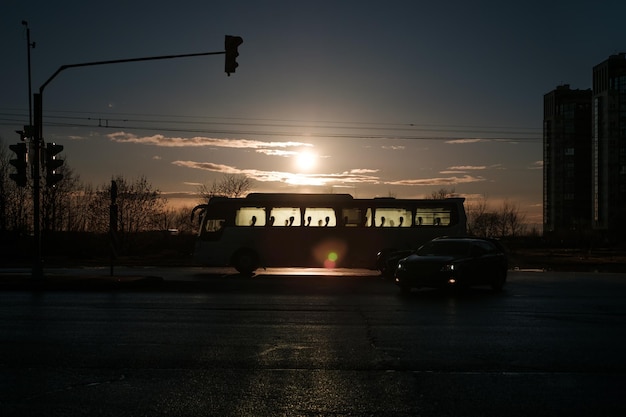 Silhueta de um ônibus urbano no fundo do sol poente