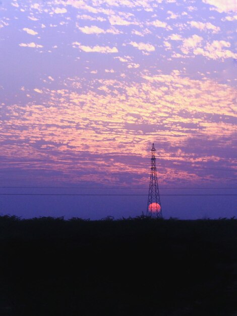 Silhueta de um pilar de eletricidade contra o céu durante o pôr do sol